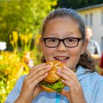 Ein Mädchen hat einen Burger in der Hand