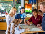 Eine Familie wird von einer Mitarbeiterin des Biosphärenzentrums beraten
