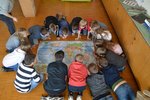 Kinder sitzen um eine Landkarte auf dem Boden und erarbeiten das Klimaschutzprojekt