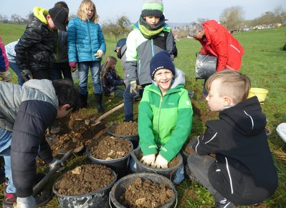 Kinder mit Eimer voller Erde