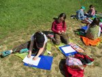 Kinder am Lernen auf einer Wiese an einem sonnigen Tag