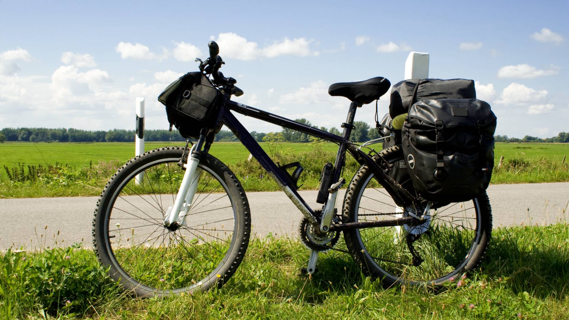 Ein Fahrrad steht bepackt am Straßenrand